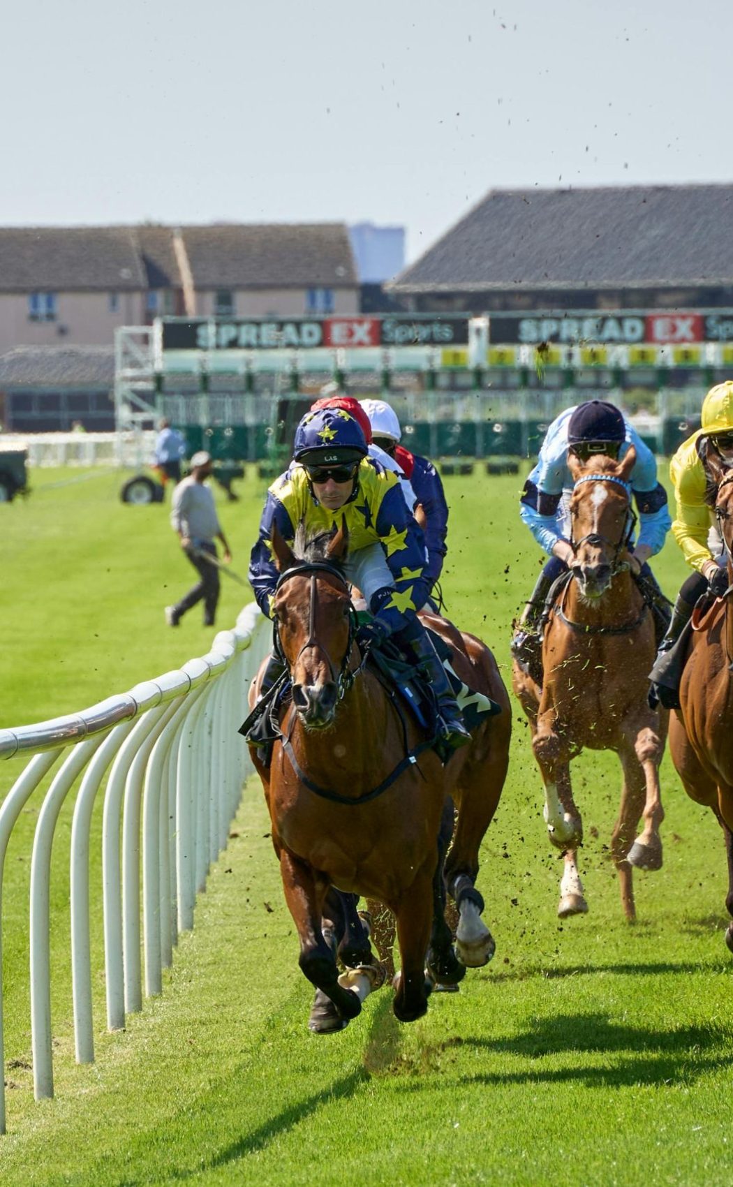 Jockeys compete intensely at the Musselburgh Racecourse in Scotland, showcasing equestrian skill and speed.